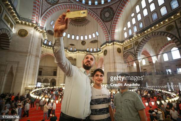 Muslims take a selfie after performed Eid al-Fitr prayer at Suleymaniye Mosque in Istanbul, Turkey on June 15, 2018. Eid al-Fitr is a religious...