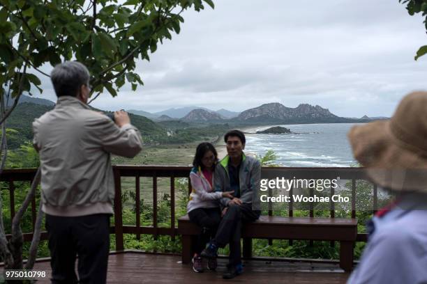 South Korean tourists take souvenir picture with North Korean scenary at Goseong Unification Observatory on June 10, 2018 in Hyeonnae, South Korea....