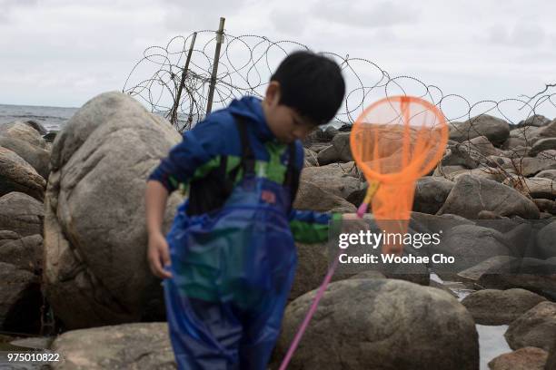 Boy catches crabs on the beach on June 9, 2018 in Hyeonnae, South Korea. Around 2,700 South Korean villagers live under tight military defense at...