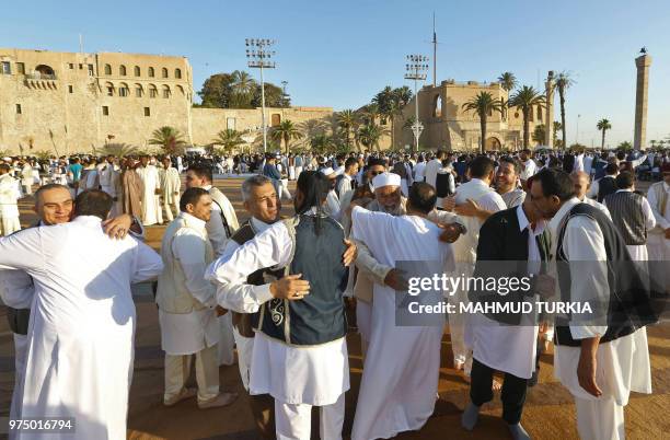 Libyan Muslim worshipers gather to perform Eid al-Fitr prayers at the Martyrs' Square in the capital Tripoli on June 15, 2018 to mark the end of the...