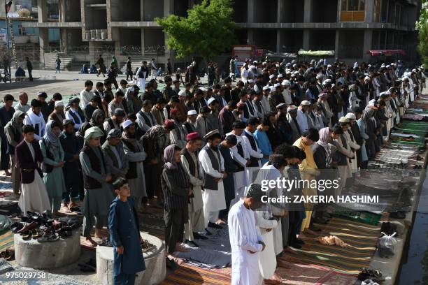 Afghan residents offer prayers at the start of the Eid al-Fitr holiday which marks the end of the holy month of Ramadan at a mosque in Ghazni on June...