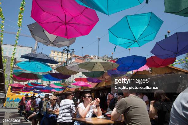 May 2018, Lissabon, Portugal: Coloful umbrellas hanging above a market at the Largo Corpo Santo. Numerous music fans, gather in Lissabon for the...