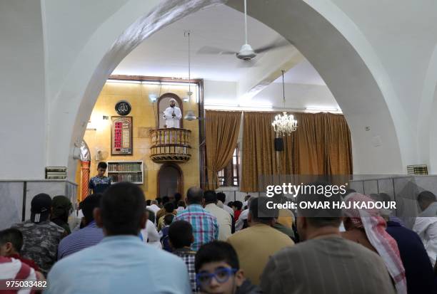 Syrian men perform morning prayers during the celebrations of Eid al-Fitr in Binnish, northwestern Syria, on June 15, 2018. - Muslims worldwide...