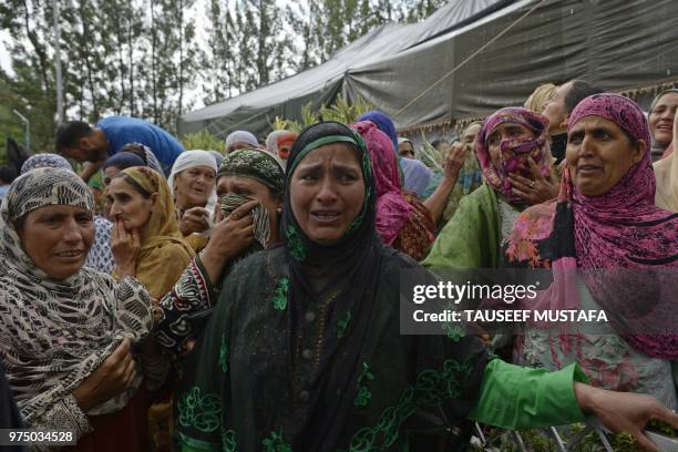 Relatives of a slain editor-in-chief of the Srinagar-based newspaper Rising Kashmir Shujaat Bukhari mourn during the funeral procession at Kreeri,...