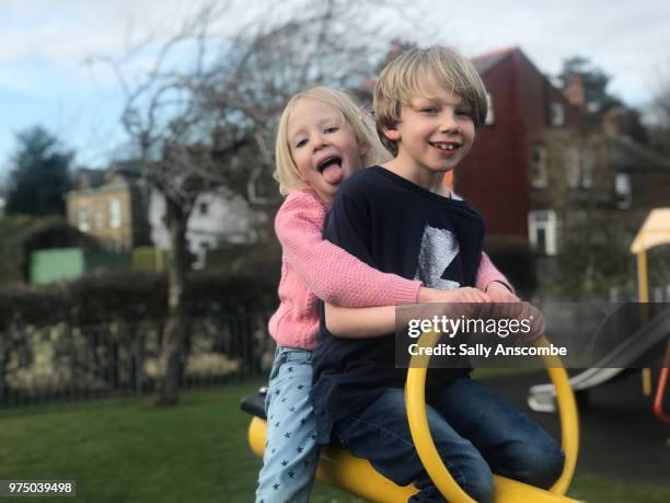 children on a seesaw together - sally anscombe stock-fotos und bilder