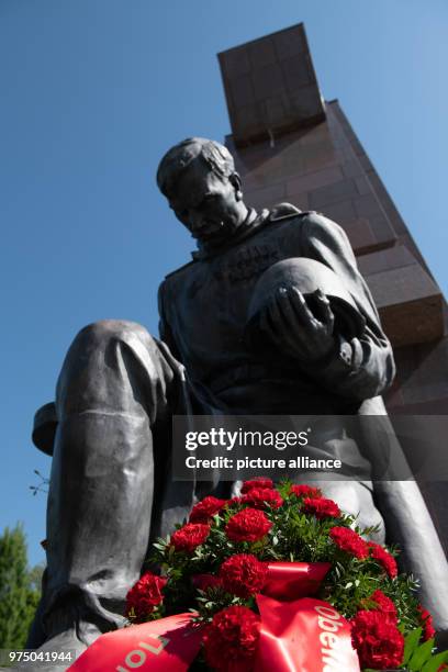 May 2018, Germany, Berlin: Red carnations lying by a statue on the occasion of the "Day of Victory" on the grounds of the Soviet war memorial in...