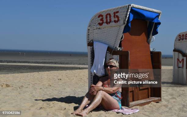 May 2018, Germany, Cuxhaven: Edith leans on a closed wicker beach chair in the sun. Photo: Carmen Jaspersen/dpa