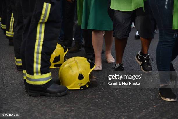 Firefighters line the street join a silent march to St Mark's Park where an open Iftar will take place on the one year anniversary of the Grenfell...