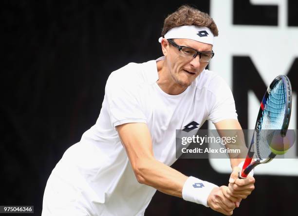 Denis Istomin of Uzbekistan plays a backhand to Lucas Pouille of France during day 5 of the Mercedes Cup at Tennisclub Weissenhof on June 15, 2018 in...