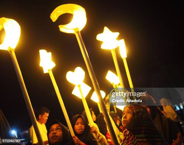 Number of young people carry lanterns bearing Asmaul Husna or the name of Allah, in the evening parade of takbeer welcoming Eid al-Fitr in the next...