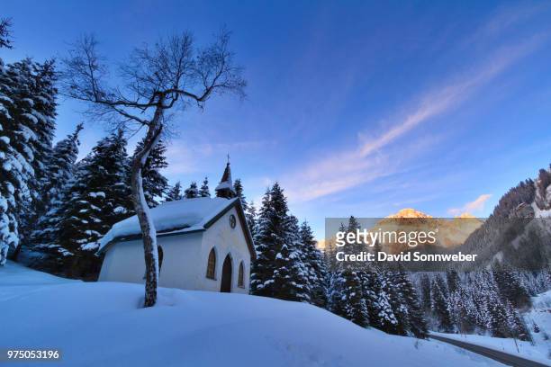 maria-hilf-kapelle in snow and mountains in the background, tirol, austria - kapelle stock pictures, royalty-free photos & images