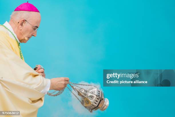 May 2018, Germany, Muenster: Muenster's bishop, Felix Genn, waving frankincense at a service in front of the castle for Ascension Day. From the 09...