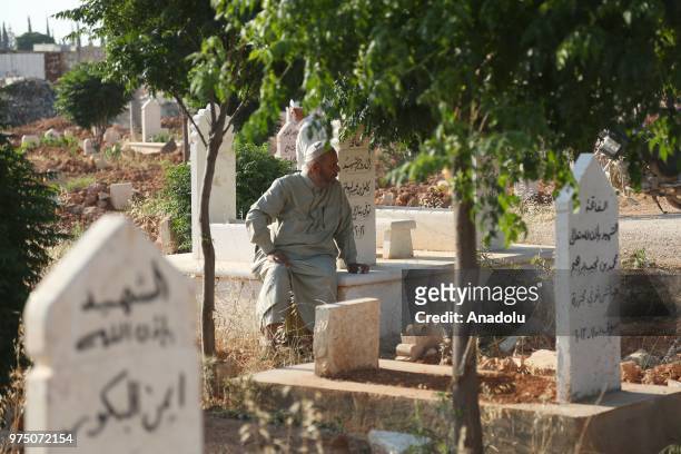 Syrian people visit graves of their relatives following performing Eid al-Fitr prayer in Al-Bab district of Aleppo, Syria on June 15, 2018. Turkey's...