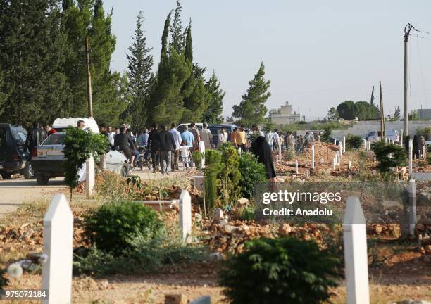 Syrian people visit graves of their relatives following performing Eid al-Fitr prayer in Al-Bab district of Aleppo, Syria on June 15, 2018. Turkey's...