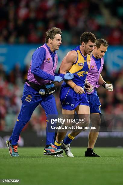 Luke Shuey of the Eagles is assisted from the field during the round 13 AFL match between the Sydney Swans and the West Coast Eagles at Sydney...