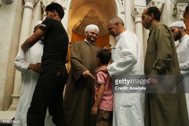 Syrian people greet each other after performed Eid al-Fitr prayer at Ez Zehra Mosque in Al-Bab district of Aleppo, Syria on June 15, 2018. Turkey's...