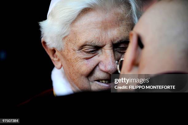 Pope Benedict XVI speaks to a priest during a visit to the San Giovanni della Croce Parish in Rome on March 7, 2010. AFP PHOTO / Filippo MONTEFORTE