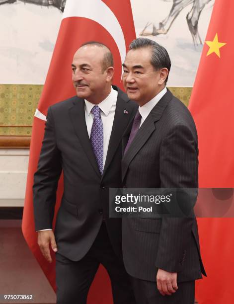 Turkish Foreign Minister Mevlut Cavusoglu walks with Chinese Foreign Minister Wang Yi before a meeting on June 15, 2018 in Beijing, China.