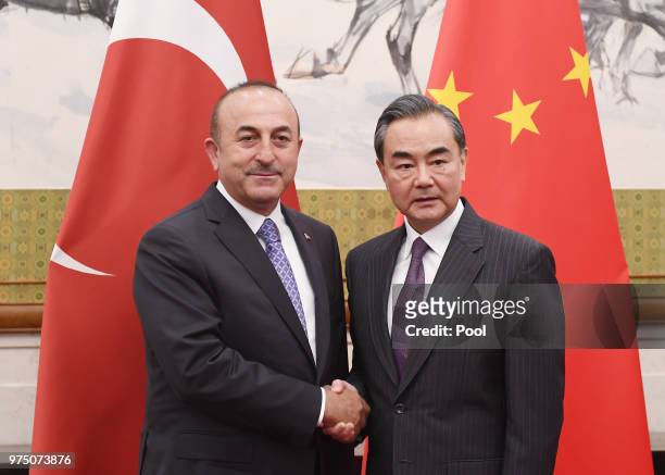 Turkish Foreign Minister Mevlut Cavusoglu shakes hands with Chinese Foreign Minister Wang Yi before a meeting on June 15, 2018 in Beijing, China.