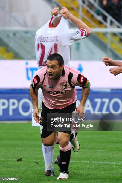 Fabrizio Miccoli of Palermo celebrates after scoring as Mozart of Livorno shows his dejection during the Serie A match between US Citta di Palermo...
