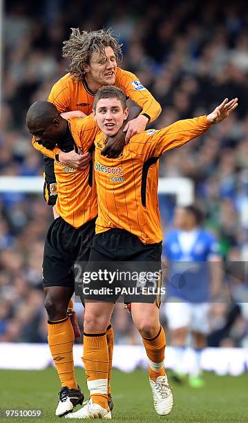 Hull City's English midfielder Tom Cairney celebrates scoring against Everton with George Boeteng and Jimmy Bullard during their English Premier...