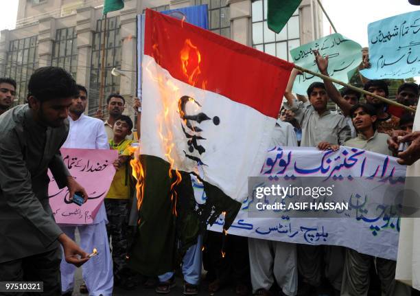 Pakistani activists of Baloch Rights Council burn an Iranian flag during a demonstration in support of top Sunni militant leader Abdolmalek Rigi in...