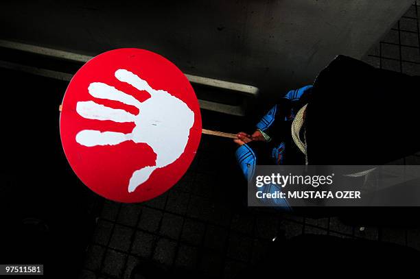 Young boy holds a placard on February 28, 2010 in downtown Istanbul where some 2,000 people gathered to demonstrate against coups d'etat in Turkey....