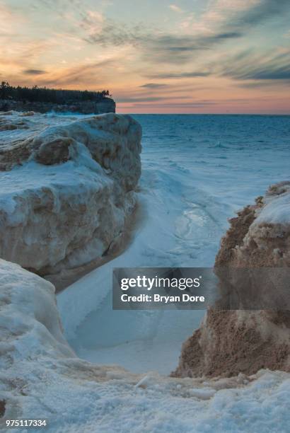 frozen lake superior at sunset, michigan, usa - pictured rocks in winter stock-fotos und bilder