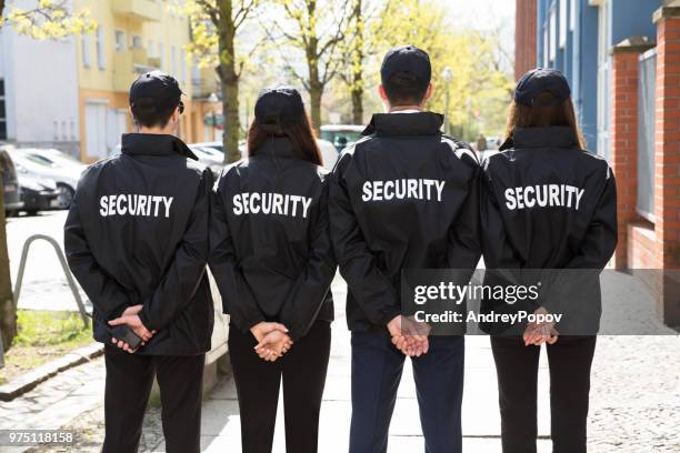 Rear View Of Security Guards Standing In A Row