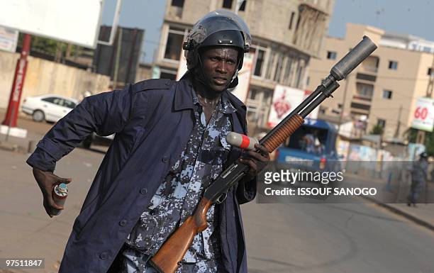 Togolese gendarme prepares to fire tear gas at supporters of Jean-Pierre Fabre, leader of the Union of Forces of Change , the main party of the...