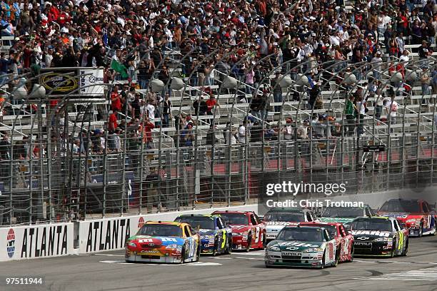 Dale Earnhardt Jr., driver of the AMP Energy/National Guard Chevrolet, and Kyle Busch, driver of the M&M's Toyota, leads the field to the green flag...