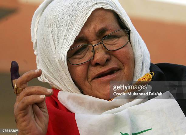 An Iraqi woman shows her inked finger after voting for the country's parliamentary elections March 7, 2010 at a polling station in Baghdad, Iraq....