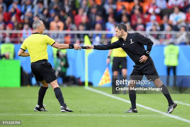 Fourth Official Milorad Mazic hands Referee Bjorn Kuipers some vanishing spray during the 2018 FIFA World Cup Russia group A match between Egypt and...