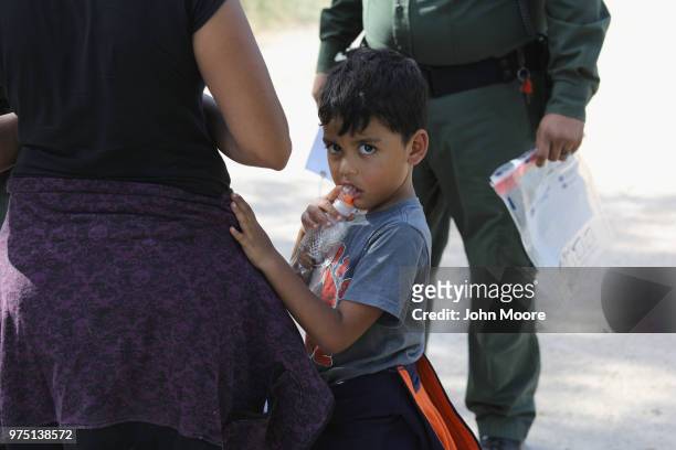 Central American asylum seekers wait as U.S. Border Patrol agents take them into custody on June 12, 2018 near McAllen, Texas. The families were then...