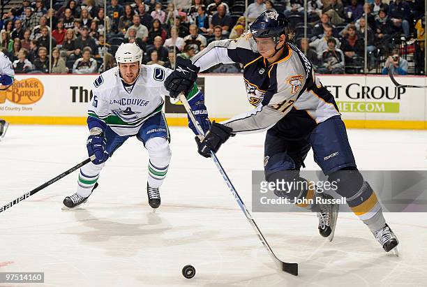 Denis Grebeshkov of the Nashville Predators skates against Shane O'Brien of the Vancouver Canucks on March 7, 2010 at the Bridgestone Arena in...