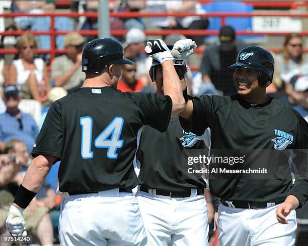 Infielder Randy Ruiz of the Toronto Blue Jays celebrates a grand slam home run with catcher John Buck against the Detroit Tigers March 7, 2010 at...