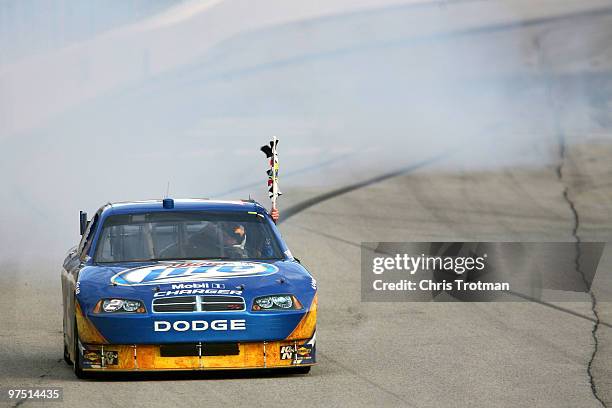 Kurt Busch, driver of the Miller Lite Dodge, celebrates on track after winning the NASCAR Sprint Cup Series Kobalt Tools 500 at Atlanta Motor...