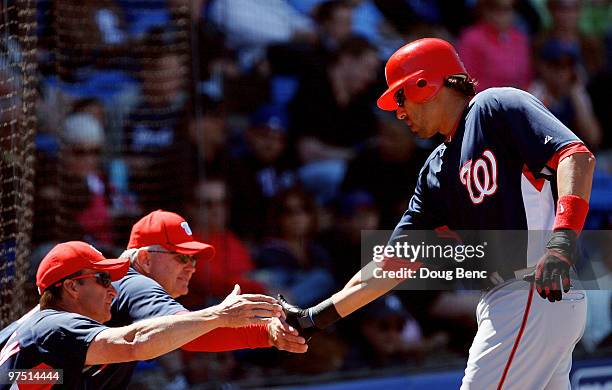 Mike Morse of the Washington Nationals is congratulated by manager Jim Riggleman and bench coach John McLaren after his two-run home run in the 1st...