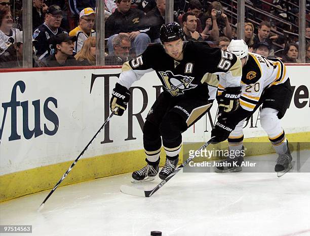 Sergei Gonchar of the Pittsburgh Penguins handles the puck by Daniel Paille of the Boston Bruins in the third period at Mellon Arena on March 7, 2010...