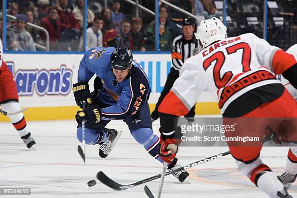 Marty Reasoner of the Atlanta Thrashers carries the puck against Brett Carson of the Carolina Hurricanes at Philips Arena on March 7, 2010 in...