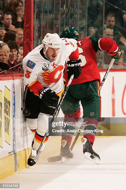 Ian White of the Calgary Flames collides with Andrew Ebbett of the Minnesota Wild during the game at the Xcel Energy Center on March 7, 2010 in Saint...