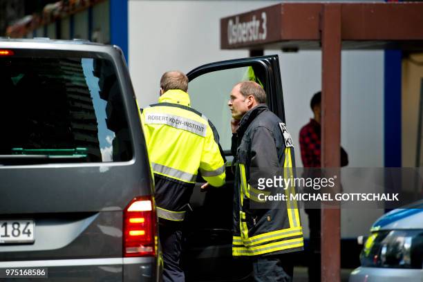 Picture taken on June 15, 2018 shows an employee of the public health Robert Koch institute in front of an apartment building in Cologne's Chorweiler...