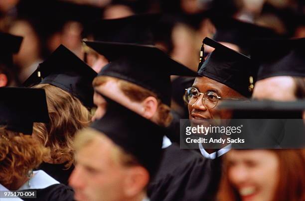 graduates at graduation ceremony (focus on young man in glasses) - university photos et images de collection