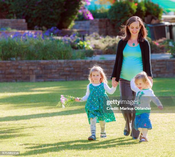 pregnant woman with her daughters walking on lawn in the park, tintenpalast, windhoek, namibia - windhoek stock pictures, royalty-free photos & images