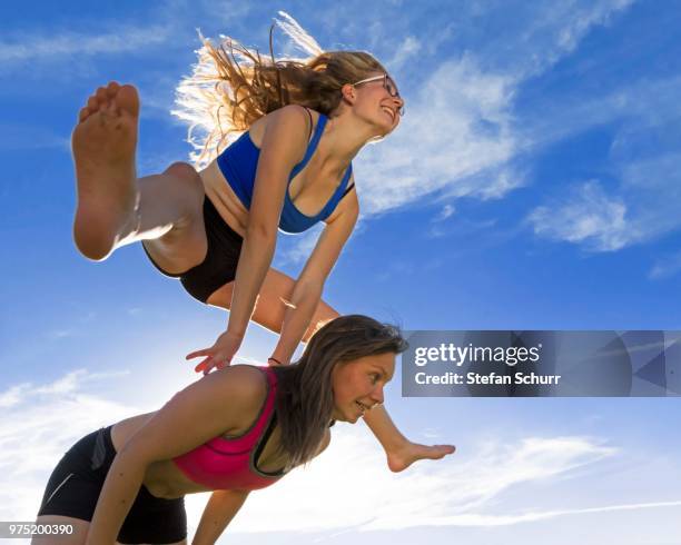 young women, 18 and 20 years, leapfrogging - 18 19 years photos foto e immagini stock