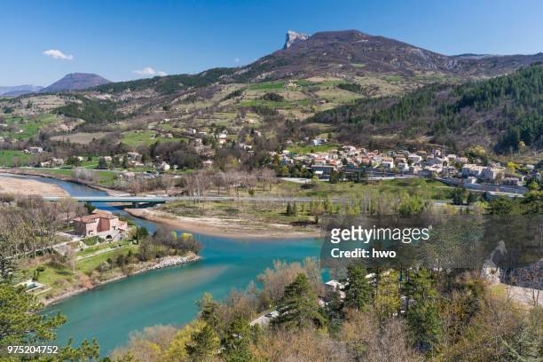 the whitewater river buech flows into the durance as right tributary, the district of faubourg de la baume and montagne de gache mountain with rocky promontory behind, sisteron, provence-alpes-cote d'azur, france - シストロン ストックフォトと画像