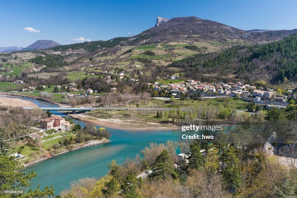 The whitewater river Buech flows into the Durance as right tributary, the district of Faubourg de la Baume and Montagne de Gache mountain with rocky promontory behind, Sisteron, Provence-Alpes-Cote d'Azur, France