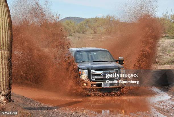 The Ford Motor Co. 2011 F-250 Super Duty Power Stroke diesel pickup truck is driven through mud during a media test drive in Yarnell, Arizona, U.S.,...