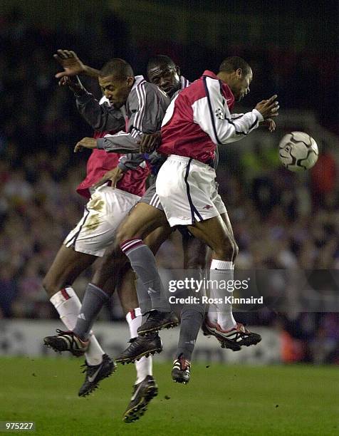 Ashley Cole of Arsenal, Sidney Govou and Marc-Vivien Foe of Olympique Lyonnais in action during the UEFA Champions League match between Arsenal and...