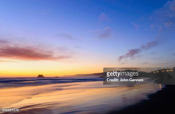 sunset at beach with hill an illuminated house, cayucos, california, usa - cayucos stock-fotos und bilder